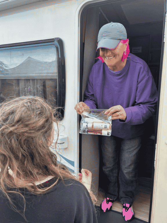 Distribution d'un kit d'hygièn par une bénévole de l'association Le Camion Douche à une personne en situation de précarité.