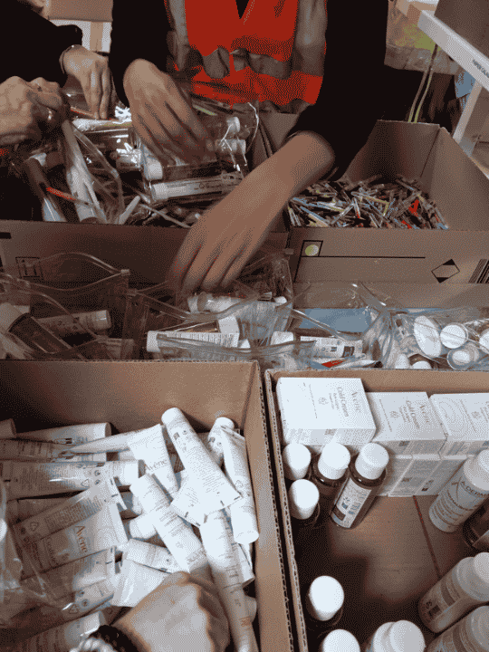 Équipes de l'Agence du Don en Nature et de l'association Le Camion Douche confectionnant ensemble des kits d'hygiène solidaire sur le site de Pierre Fabre à Muret.