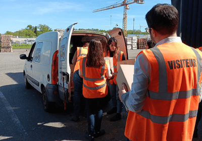 Équipes de l'ADN et du Camion Douche transportant des colis de kits d'hygiène vers le camion de l'association à Muret.